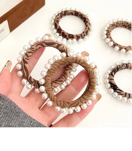Detailed view of leopard and zebra print hair ties with elegant faux pearl embellishments