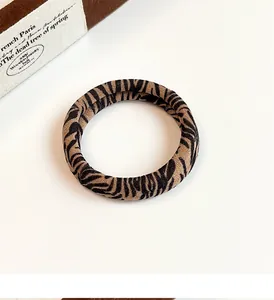 Detailed view of high-elasticity leopard print hair tie with soft velvety texture