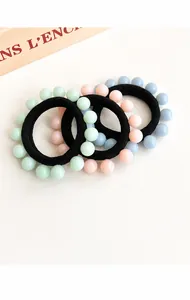 Detailed close-up of seamless elastic hair bands with pastel beads in mint, pink and blue