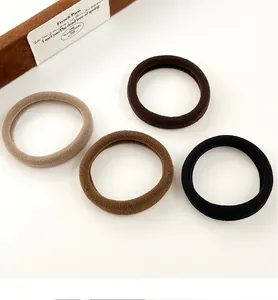Gros plan de 4 chouchous élastiques sans couture tons beige, café, marron foncé et noir