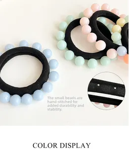 Detail of macaron color beads hand-riveted on a black elastic seamless hair tie