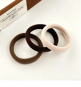 Détail de trois élastiques à cheveux sans couture en café, marron et tons beige