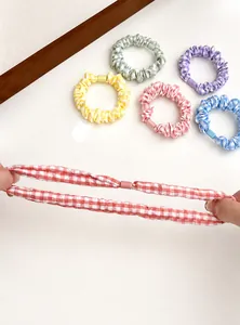 Detail showing elastic stretch of colorful plaid fabric scrunchies in pastel macaron tones