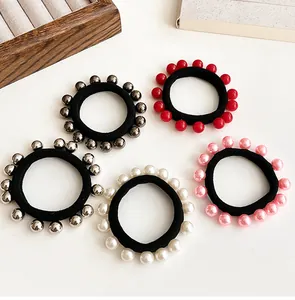 Détail de cinq élastiques à cheveux en perles en rouge, gris, argent, blanc et rose