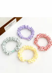 Detail of four colorful plaid scrunchies in purple, green, yellow and orange set