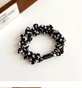 Nahaufnahme von Scrunchie mit Leopardenmuster, seidigem Faltenstoff und Schnalle