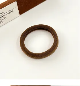 Gros plan d'un élastique à cheveux marron foncé sans couture avec une texture tricotée douce
