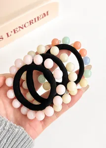 Macro detail of elastic hair ties with colorful macaron beads on a white background