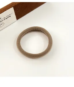 Gros plan détaillé de l'élastique à cheveux marron café avec une texture mate douce