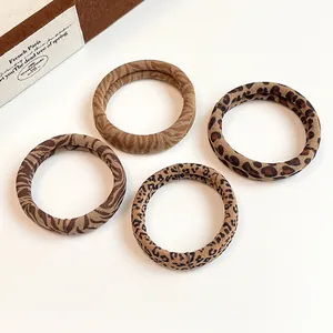 Set of four animal print elastic hair ties in leopard and tiger patterns on white background