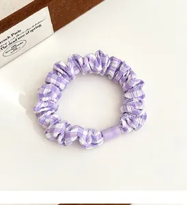 Detail view of purple gingham hair scrunchie with a stylish translucent buckle
