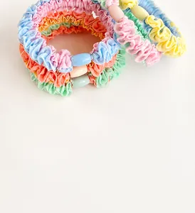 Close-up of pleated macaron hair scrunchies with decorative colorful matching beads