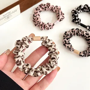 Set mit vier Haargummis mit Leopardenmuster in Rosa, Beige, Grau und Schwarzmustern