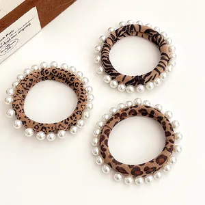 Three-piece leopard and zebra print scrunchies with white faux pearl trim decoration