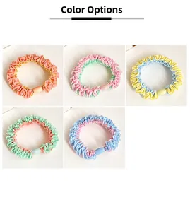 Detail of five colorful pleated fabric scrunchies with decorative oval beads in soft macaron tones
