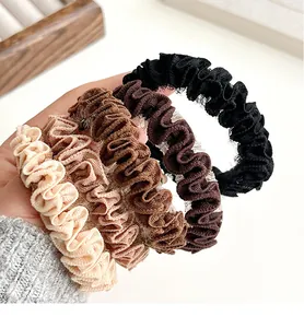 Detalle de cuatro coleteros de malla con volantes en tonos beige, marrón y negro