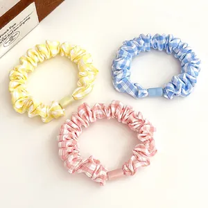 Three-piece set of plaid scrunchies in yellow, blue and pink with square plastic buckles