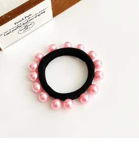 Détail d'un élastique à cheveux noir haute élasticité orné de perles roses brillantes