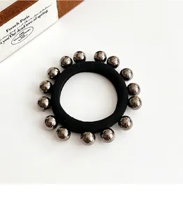 Détail d'un élastique à cheveux noir haute élasticité avec perles métalliques argentées