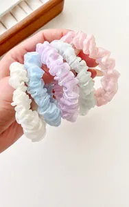Close-up of five pearlescent organza scrunchies in pastel macaron colors with high elasticity