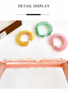 Dettaglio di elastici per capelli in organza ad alta elasticità con bordi rifiniti in oro