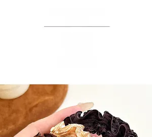 Close-up of wavy texture fabric scrunchie in coffee and beige colors for ponytails