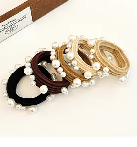 Close-up of pearl hair ties in black, coffee, camel and beige earthy tones on a desk