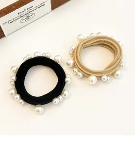 Detail of high-elasticity hair ties with white pearls in black and khaki colors