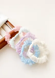Close-up of pastel pearlescent organza scrunchies set with soft pleated texture