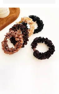 Detailed macro view of lace ruffled scrunchies in earthy tones with glossy mesh texture