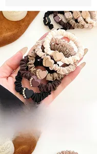 Close-up of elastic hair scrunchies with rhinestone hearts and square charms