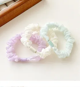 Detailed view of elastic organza scrunchies in purple, white and green shades