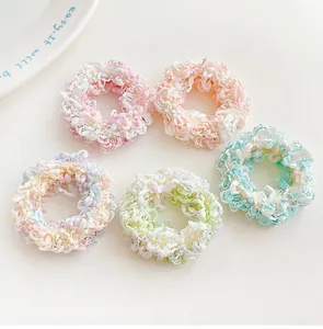 Close-up of five colorful plush scrunchies in candy tones on a clean white background