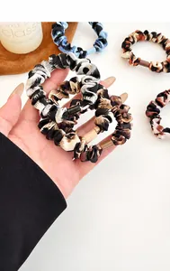 Detalle de coleteros con estampado de leopardo, hebillas acrílicas y gasa suave