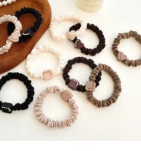 Macro detail of elastic hair scrunchies with rhinestone heart and square charms