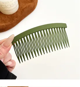 Gros plan d'un peigne à cheveux vert mat incurvé pour coiffer et fixer les mèches rebelles