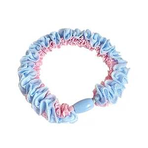 Pastel blue and pink ruffled scrunchie with a blue bead accessory on white background