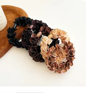 Close-up of four wavy lace hair ties in earth tones with stylish oval bead details