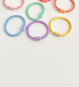 Detalle de gomas de pelo macaron de alta elasticidad con conectores cilíndricos a juego