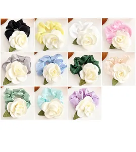 Collage de chouchous camélia en onze couleurs de satin élégantes avec accents de feuilles