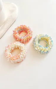 Detailed view of three pastel mesh scrunchies in pink, blue, and orange color blends