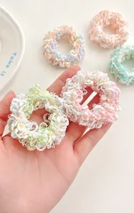 Macro detail of knit texture on cream-colored high elastic hair ties in pastel colors