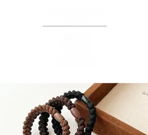 Detail of durable braided coffee and black hair ties with smooth oval decorative beads