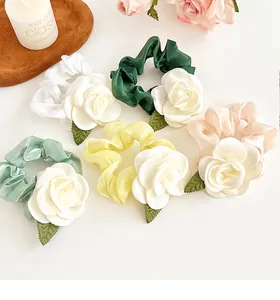 Lot de 5 chouchous en satin avec fleurs de camélia aux tons pastels sur un fond épuré