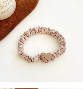 Detail of dusty pink scrunchie with heart charm and sparkling rhinestones