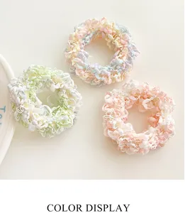 Detailed view of handmade crochet scrunchies in pastel mint, yellow and pink knit fabrics