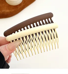 Macro shot of curved wave-teeth plastic hair combs in brown and cream colors