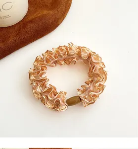 Detailed close-up of cream lace scrunchie with pleated mesh fabric and elegant resin bead