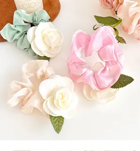 Vue détaillée des chouchous élégants en satin camélia rose, vert et champagne