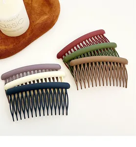 Close-up of six matte Morandi color hair combs arranged on a textured surface